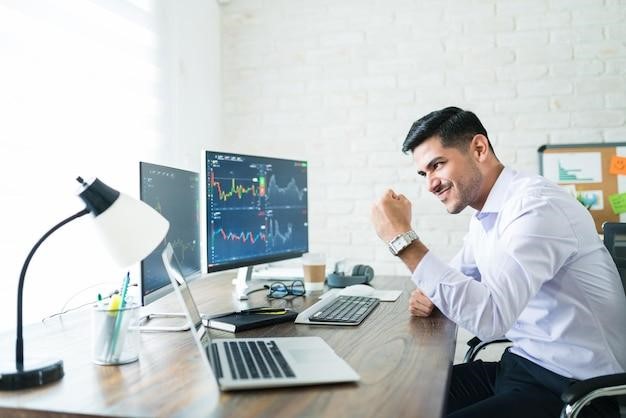 A man smiling and looking at a laptop screen